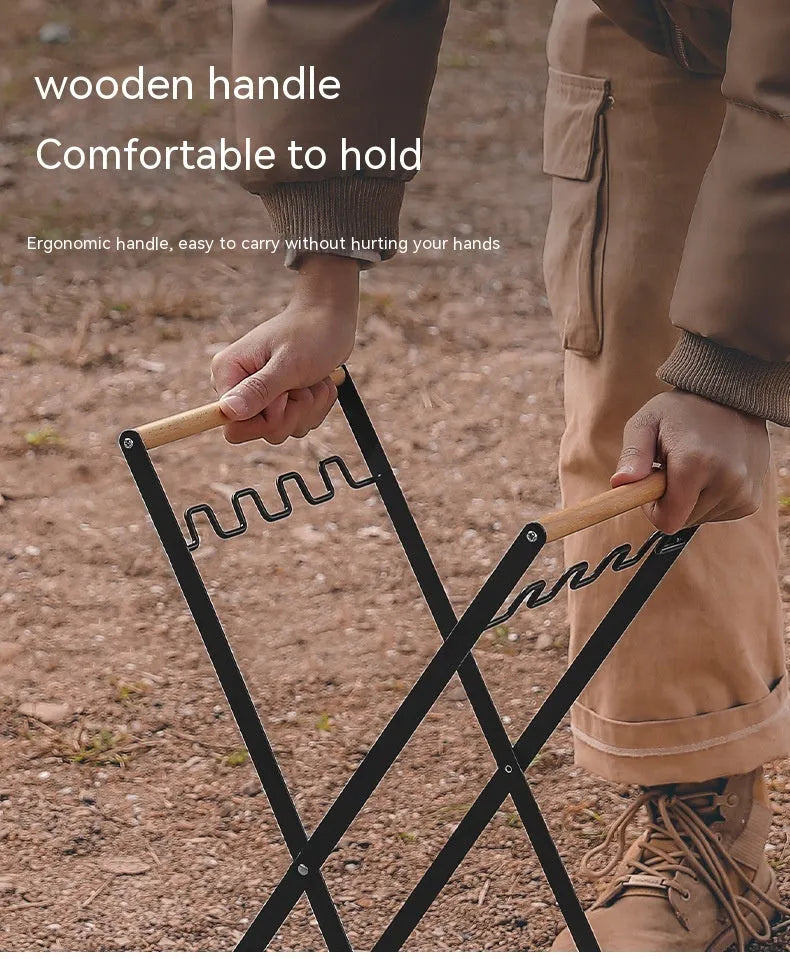 Foldable black wrought iron garbage storage hanger with a wooden handle, shown holding a bin bag.