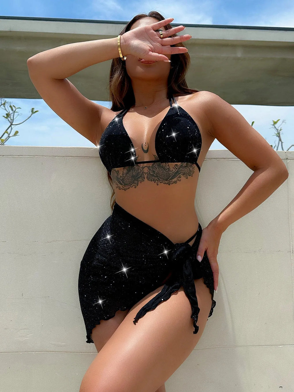 Black three-piece bikini swimsuit set with a top and shorts on a mannequin.