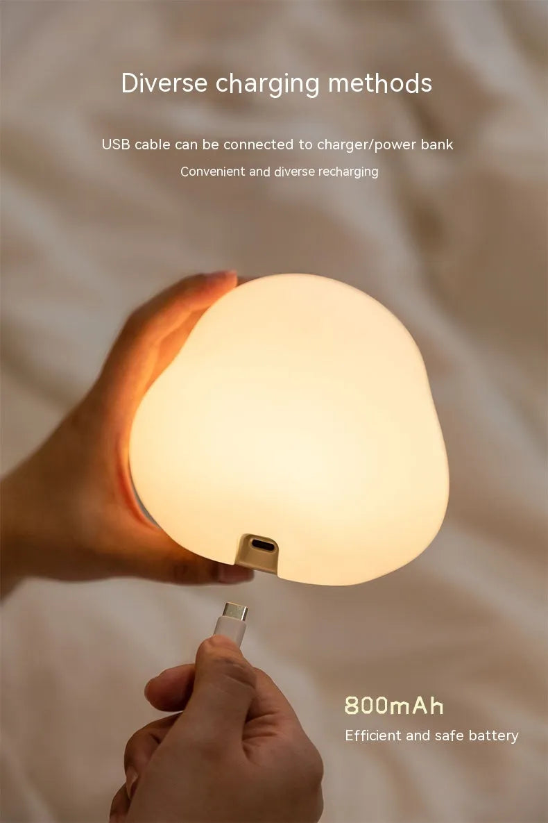 Cute duck shaped LED night lamp with silicone casing and warm light on a bedside table