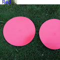 Yellow football training target disc with 23cm diameter on grass pitch