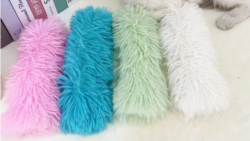 Plush cat toy pillow in green, white, blue, and pink colours measuring 27cm by 10cm