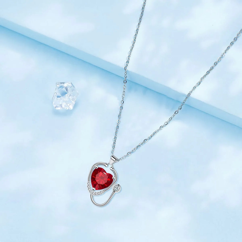 Women's fashion necklace with stethoscope, wings and cross design in red diamond colour