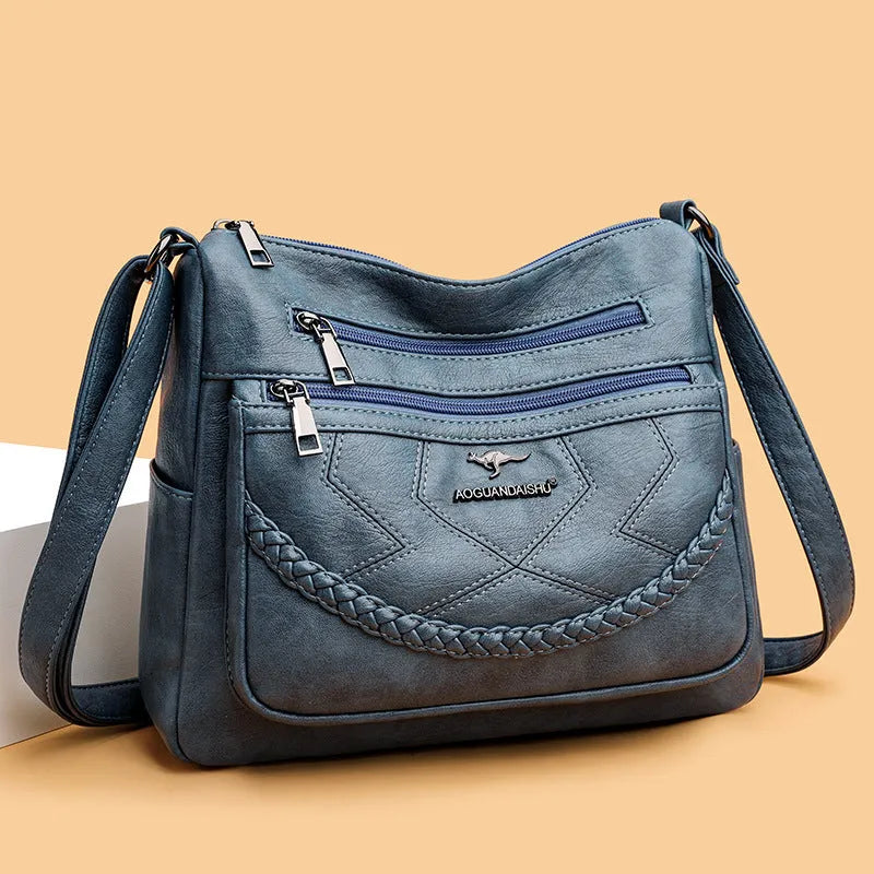 Soft PU leather women's shoulder bag in black colour showing crossbody strap and exterior pockets