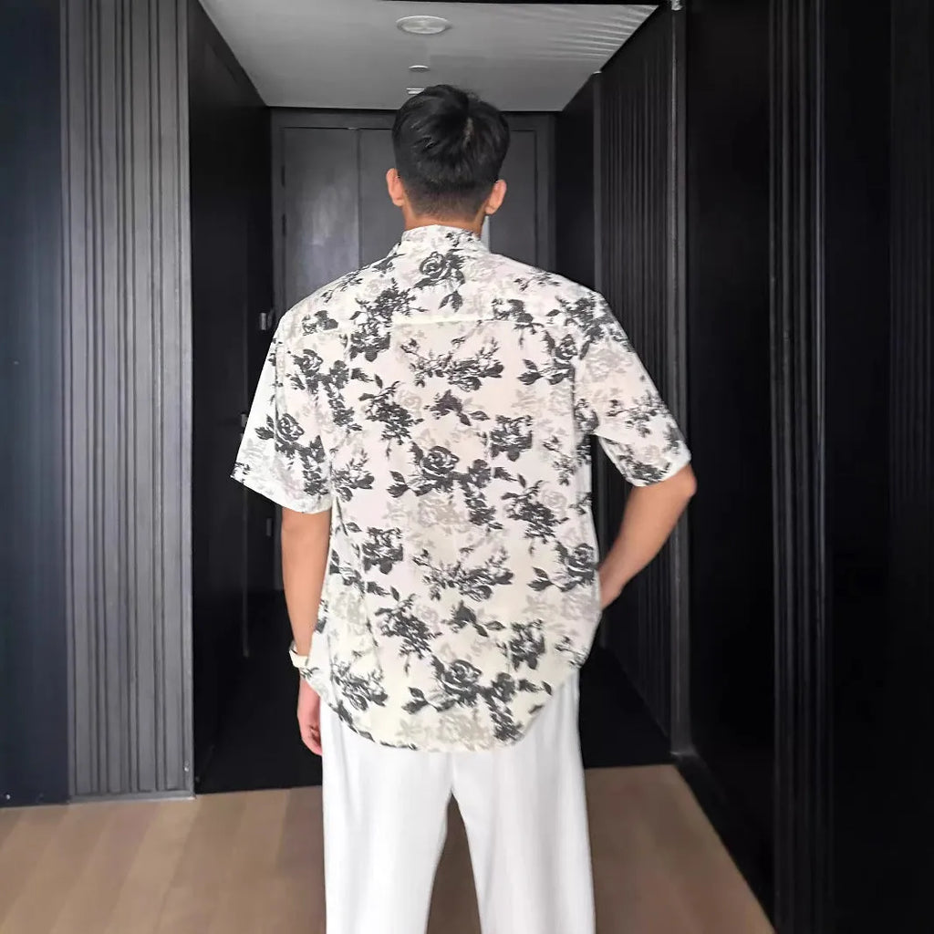 Loose fitting floral printed short sleeve shirt in black on a hanger