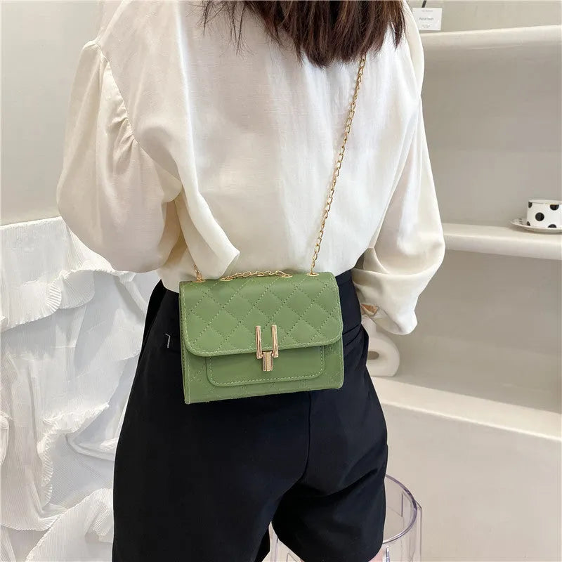 Women's black PU leather crossbody bag with diamond lattice chain detail and adjustable shoulder strap