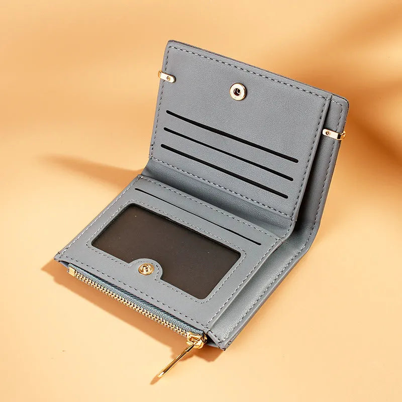 Short black ladies wallet with zipper, open to show multiple card slots, bill holder, and change compartment.