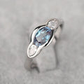 Women's geometric ellipse ring with inlaid zircon stone in white gold colour, shown on a hand.