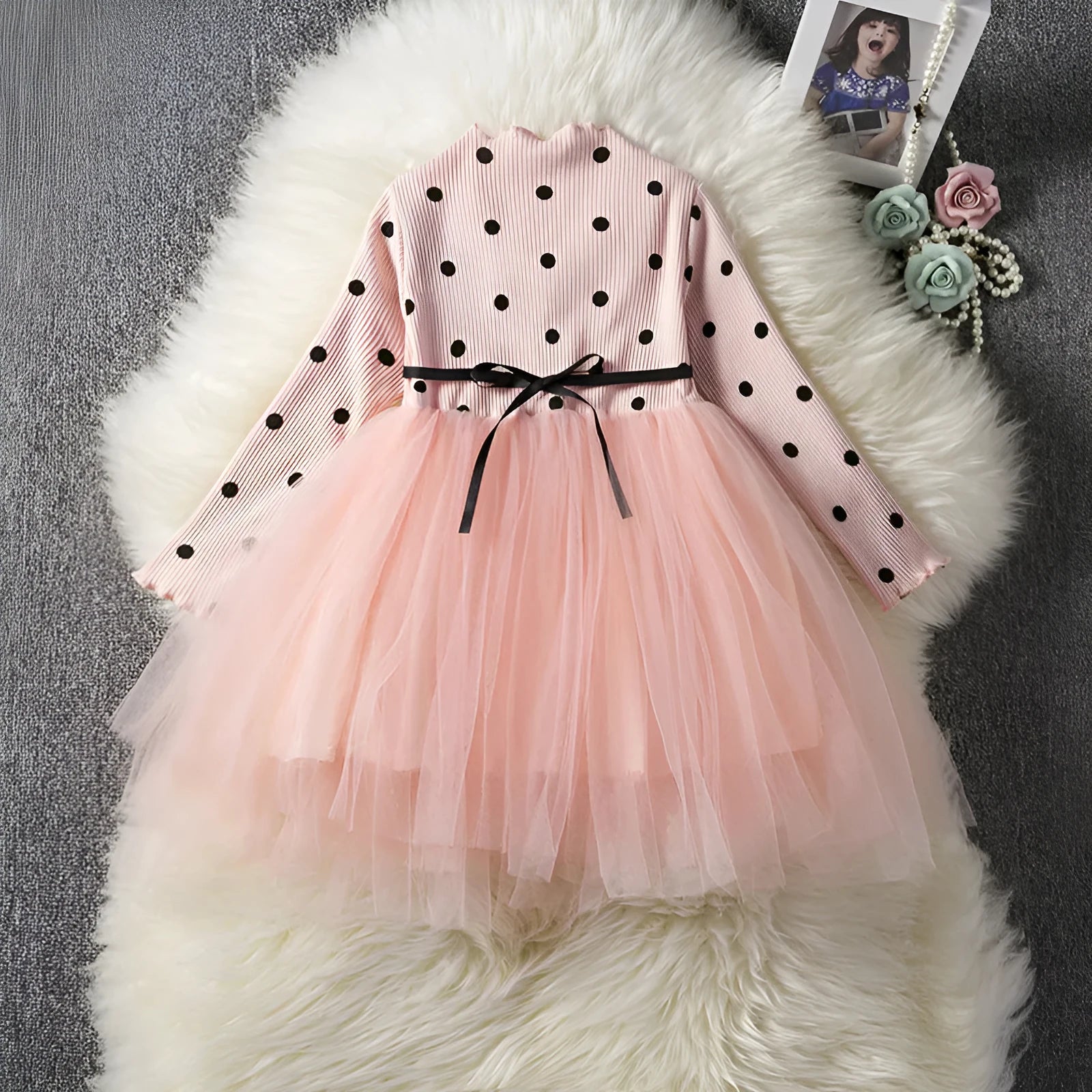 Baby girl wearing a long sleeve white lace tutu dress for a christening or birthday party.