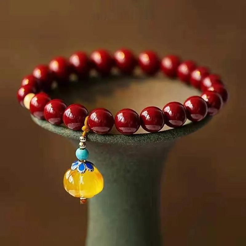 Close-up of a handcrafted wave-pattern bracelet made from red cinnabar and copper beads.