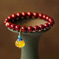 Close-up of a handcrafted wave-pattern bracelet made from red cinnabar and copper beads.