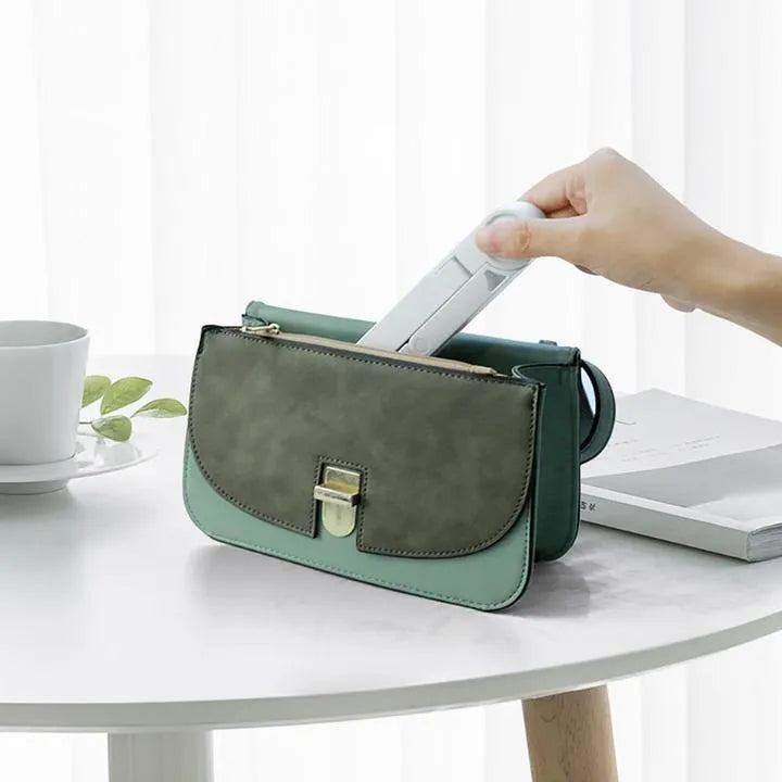 Black foldable tablet holder supporting a smartphone in landscape viewing mode on a desk.
