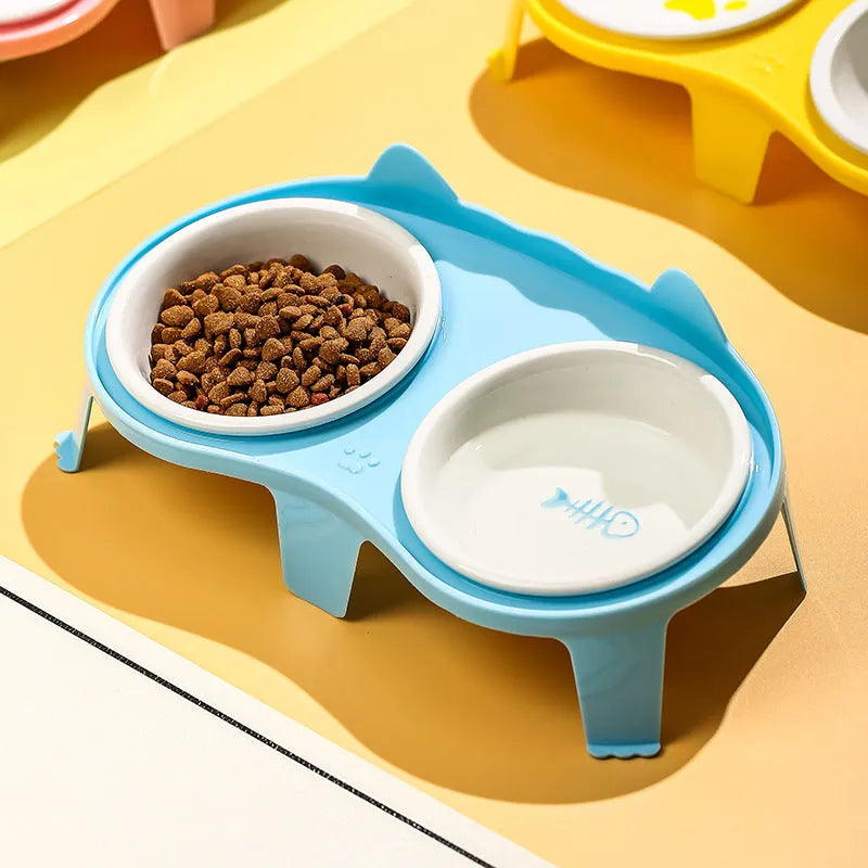 Blue ceramic cat food and water bowls on a white elevated plastic stand with a hook