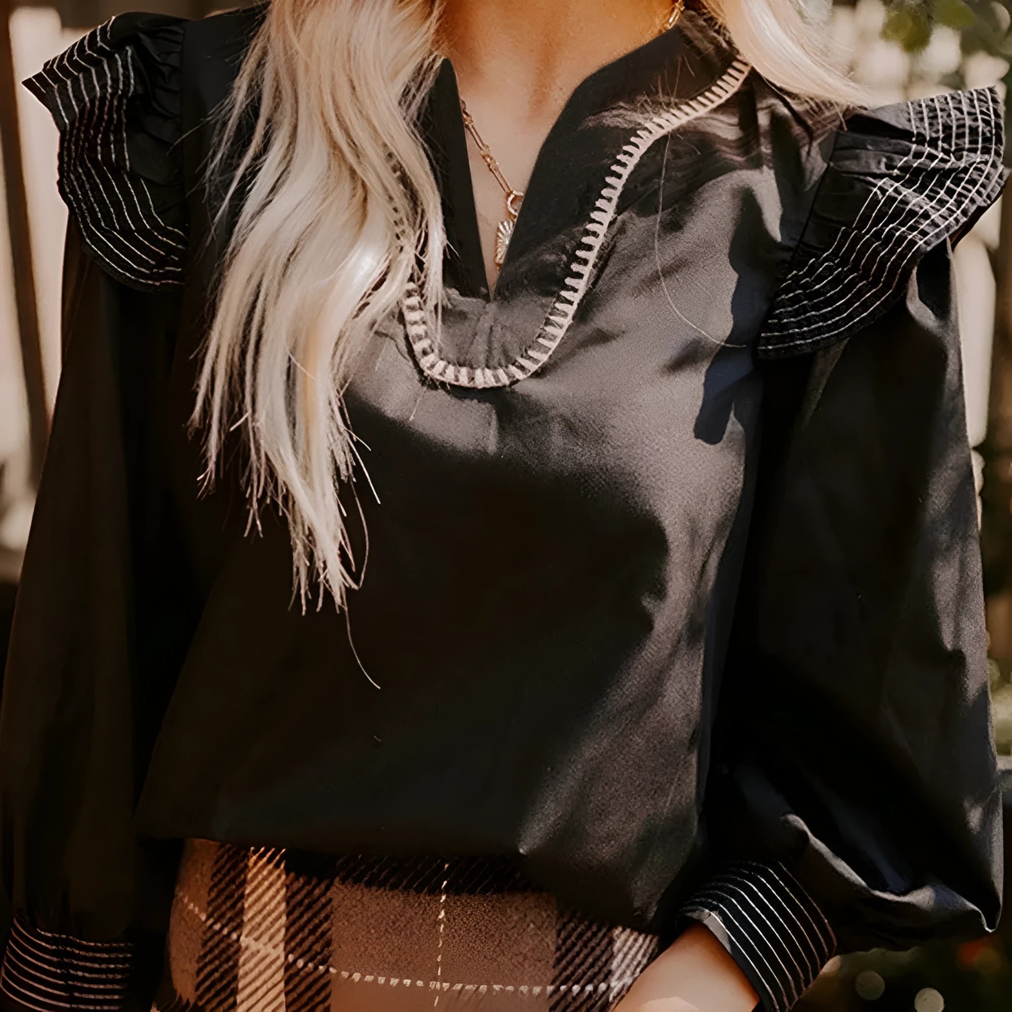 Black V-neck blouse with contrast stitching and ruffle long sleeves