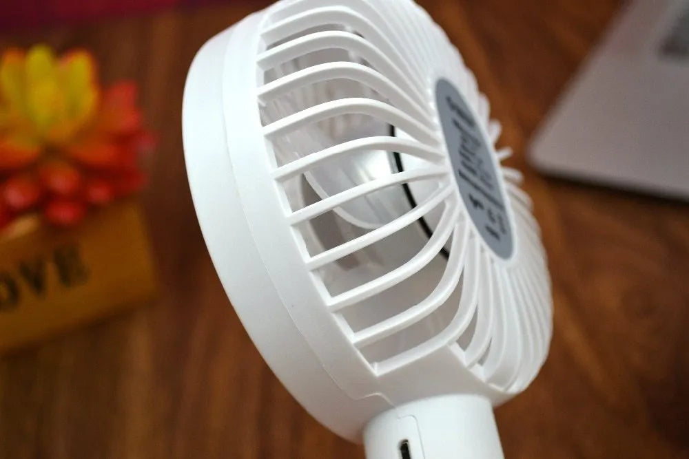 White ORICO FH1 USB rechargeable desk fan with fine-line texture on a desk, showing compact size.