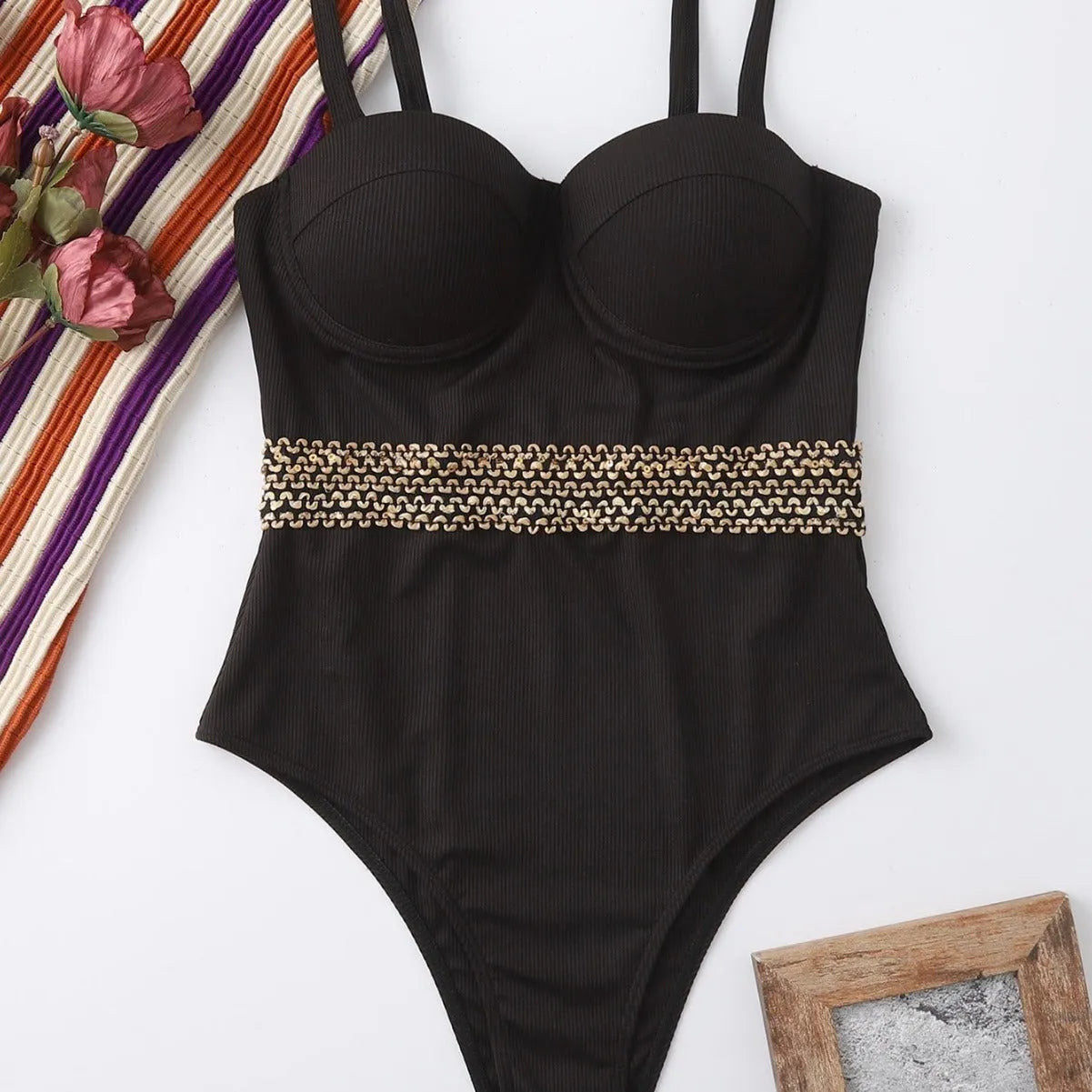Black women's one-piece swimsuit with adjustable shoulder straps on hanger with hard storage bag