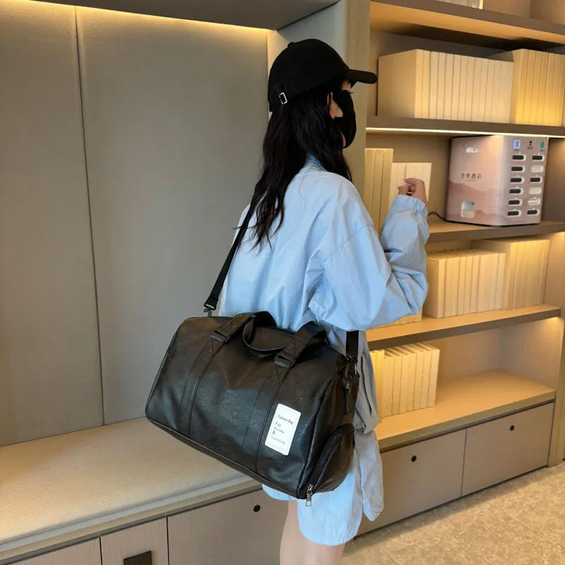 Black fitness shoulder messenger bag showing dry wet separation compartment and shoulder strap.