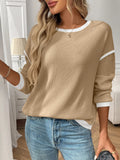 Women's loose-fitting long-sleeve polyester top in a round-neck pullover style on a hanger.