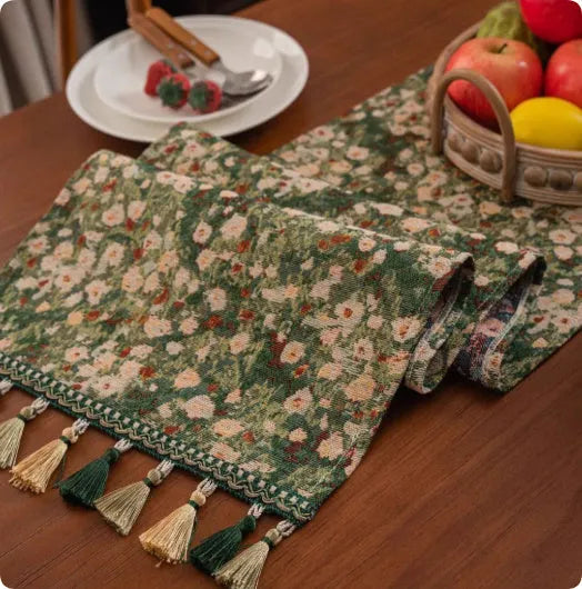 Long blue ginkgo leaf patterned table flag with tassels draped over a wooden sideboard.