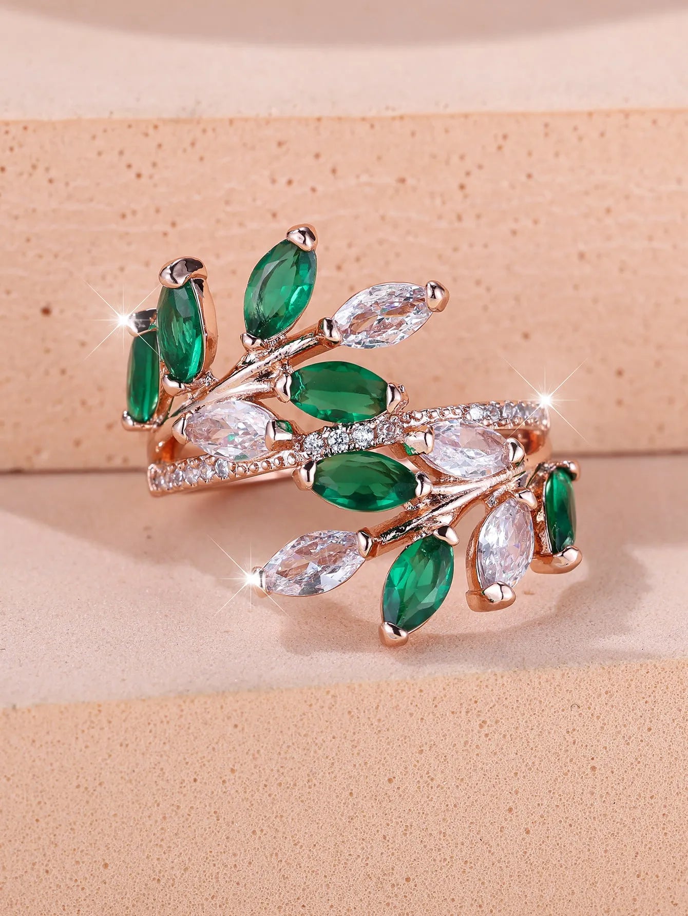 Adjustable leaf ring with horse eye zircon stone in rose gold finish on wooden background