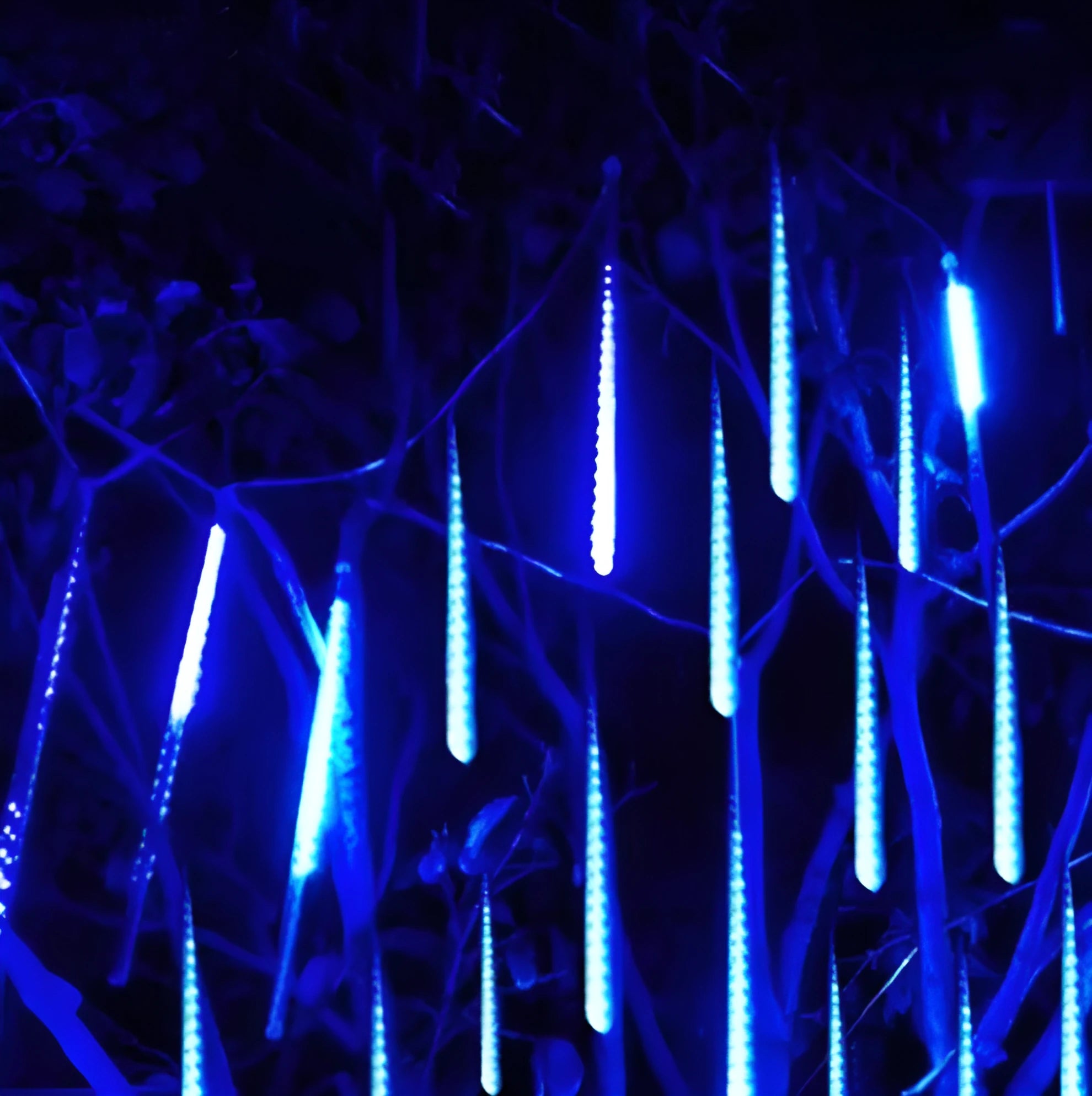Blue and white LED meteor shower lights in 50cm length with waterproof PC tubes outdoors at night.