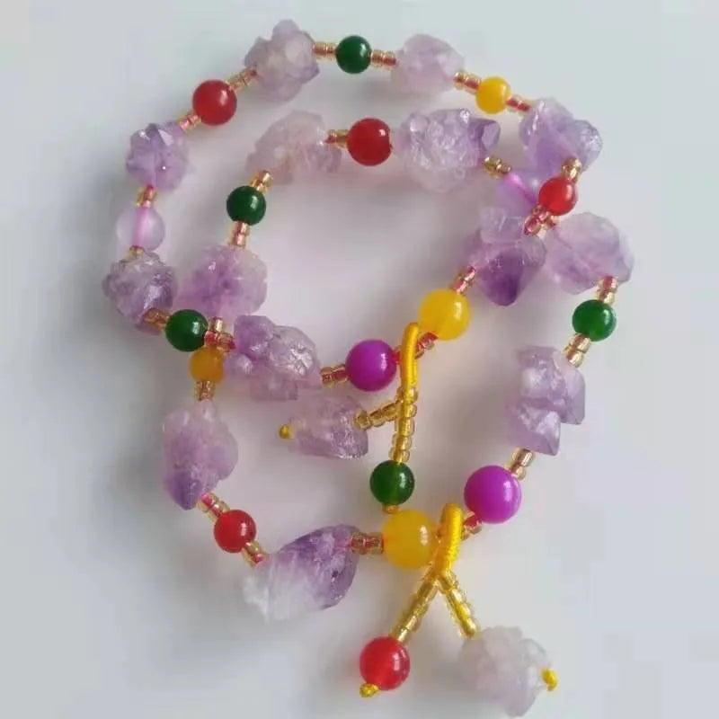 Women's natural shaped violet amethyst bead bracelet with a fu character pendant on a white background.