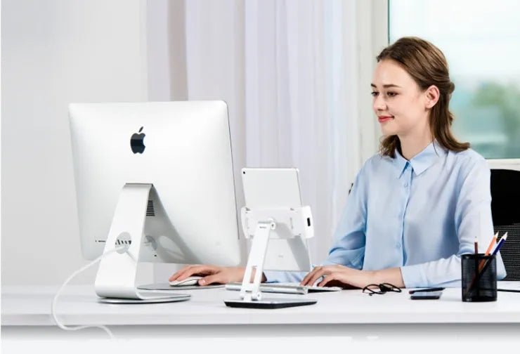 Silver aluminium folding phone and tablet stand on a desk, holding a tablet