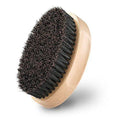 Natural boar beard brush for men in black finish with dense bristles on a table