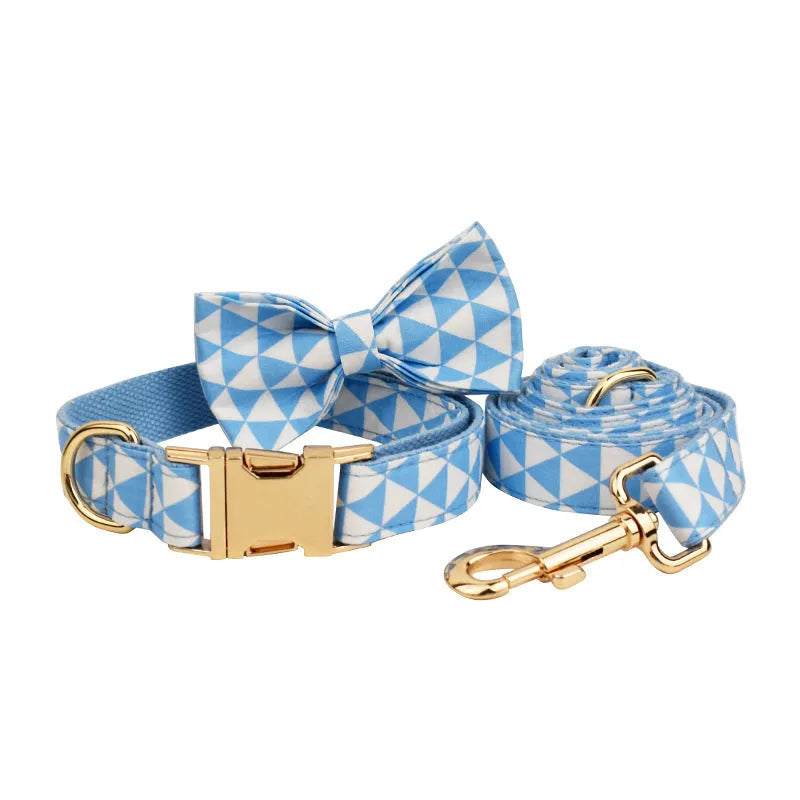 Blue cloth dog vest set with matching collar, lead, and decorative bow on a triangular ring.