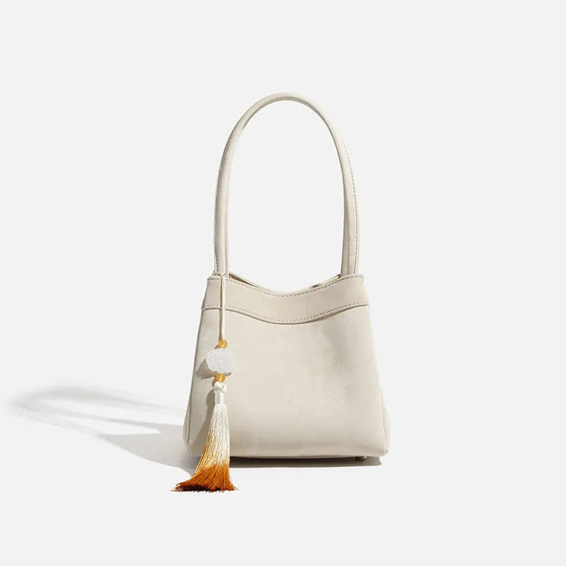 PU leather shoulder crossbody bag with single strap, tassel, open pocket, and sewing thread detail