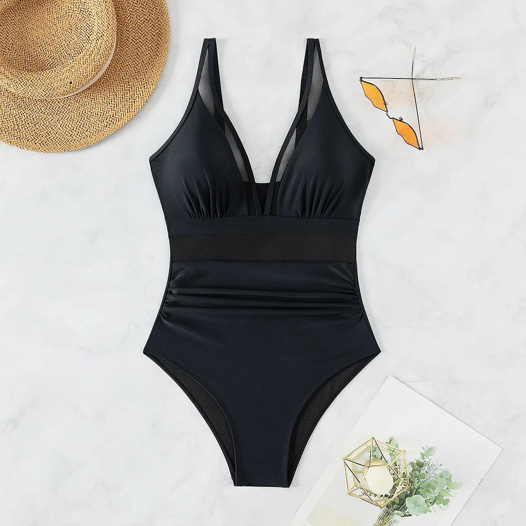 Black women's halter neck one-piece swimsuit with cross-back straps and briefs bottom.