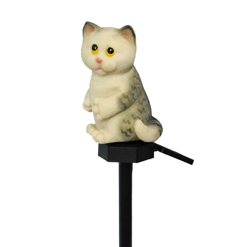 Brown cat-shaped solar lawn light in garden setting with LED illumination at dusk