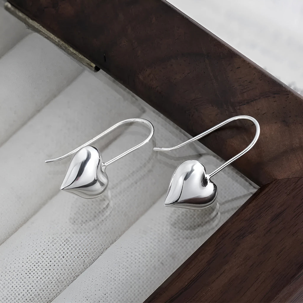Silver-coloured heart-shaped earrings with three-dimensional glossy finish and Korean-style design