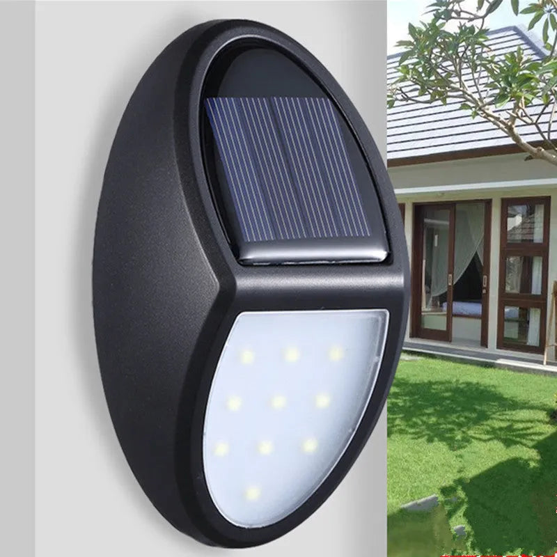Black rectangular LED solar wall light with solar panel, shown mounted on an outdoor wall.