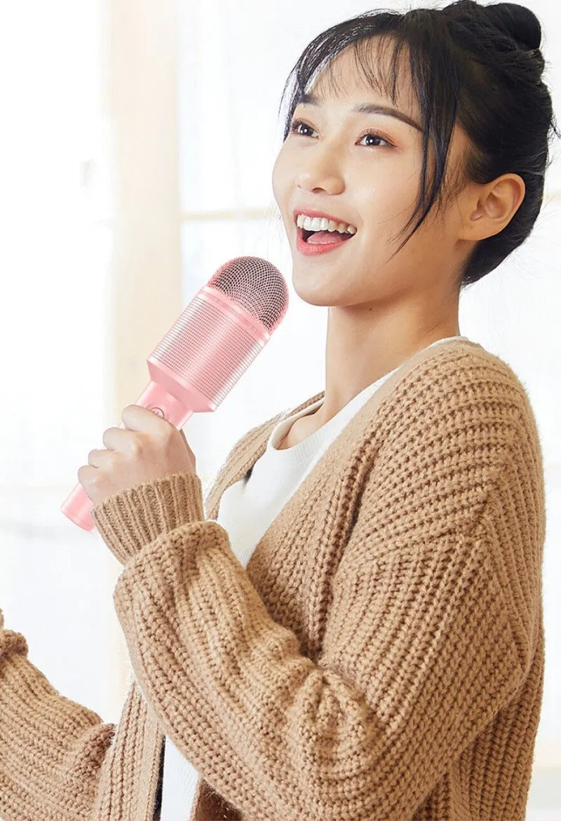 Wireless Bluetooth karaoke microphone in pink, blue, or green with integrated speaker.