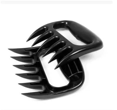 Two black PC bear claw meat shredders on a cutting board, ready for barbecue use