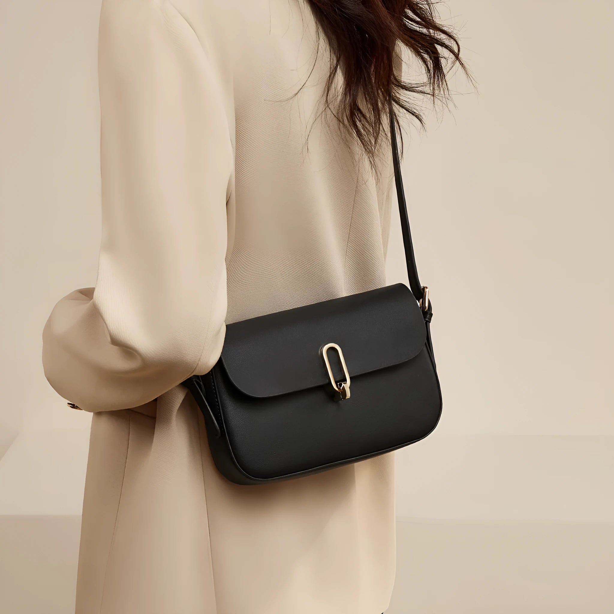 Black square leather messenger bag with shoulder strap showing lock closure and urban design