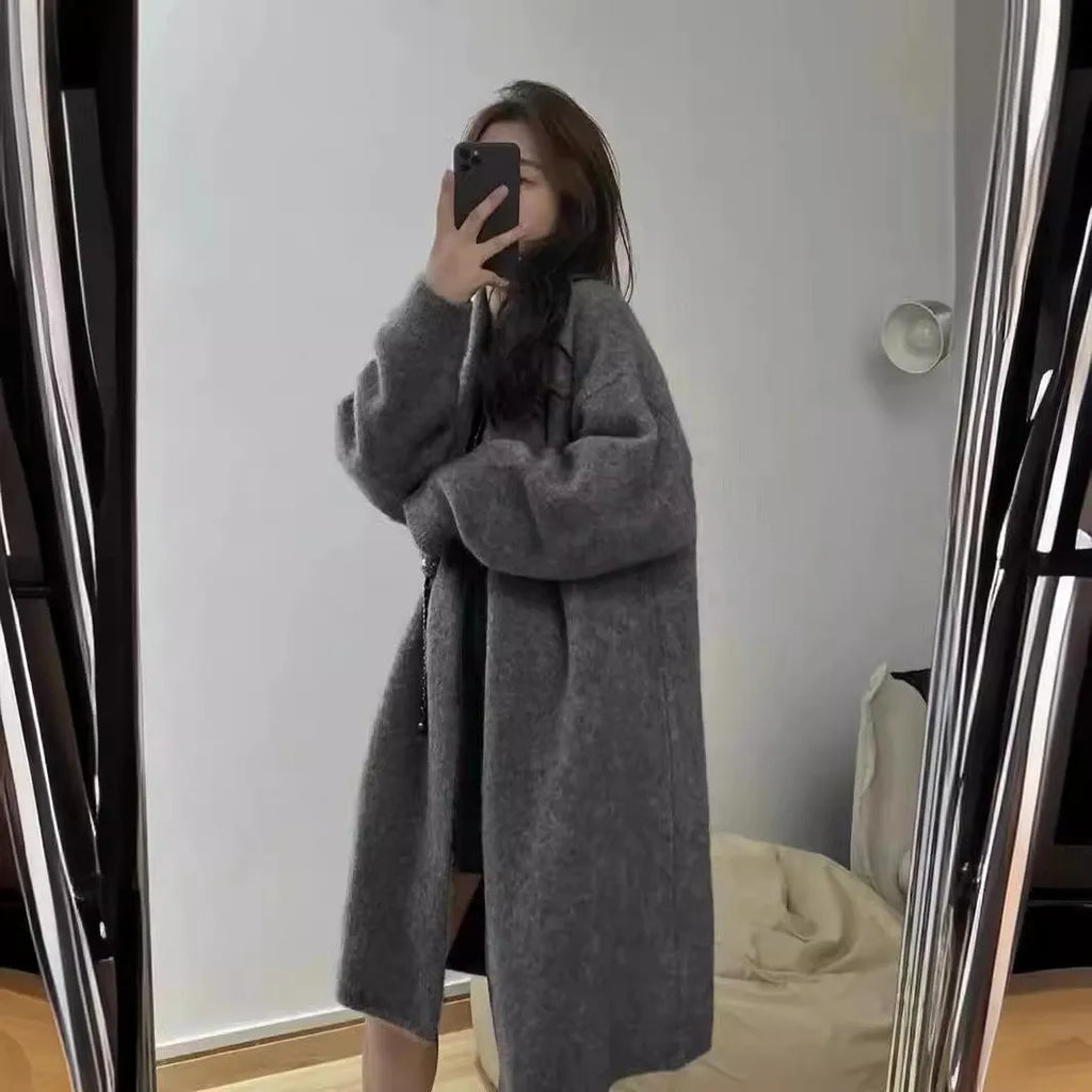 Women's loose fit grey knitted cardigan with V-neck and long sleeves, mid-length style.