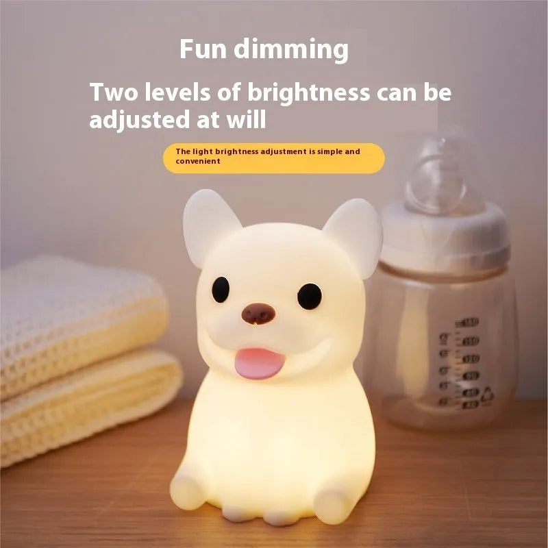 Soft silicone USB night light with dimmer in a cartoon animal design on a bedside table.