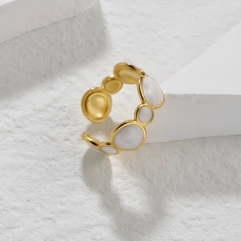 A stainless steel geometric ring with an adjustable opening on a plain background.