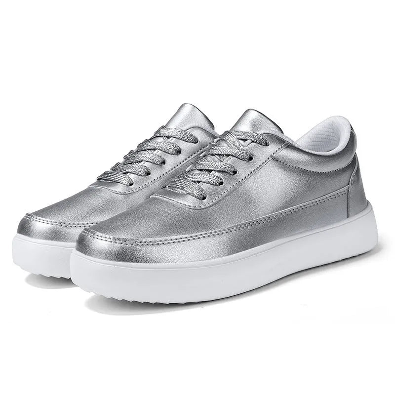 Women's white leather flat lace-up casual shoes on a plain background.