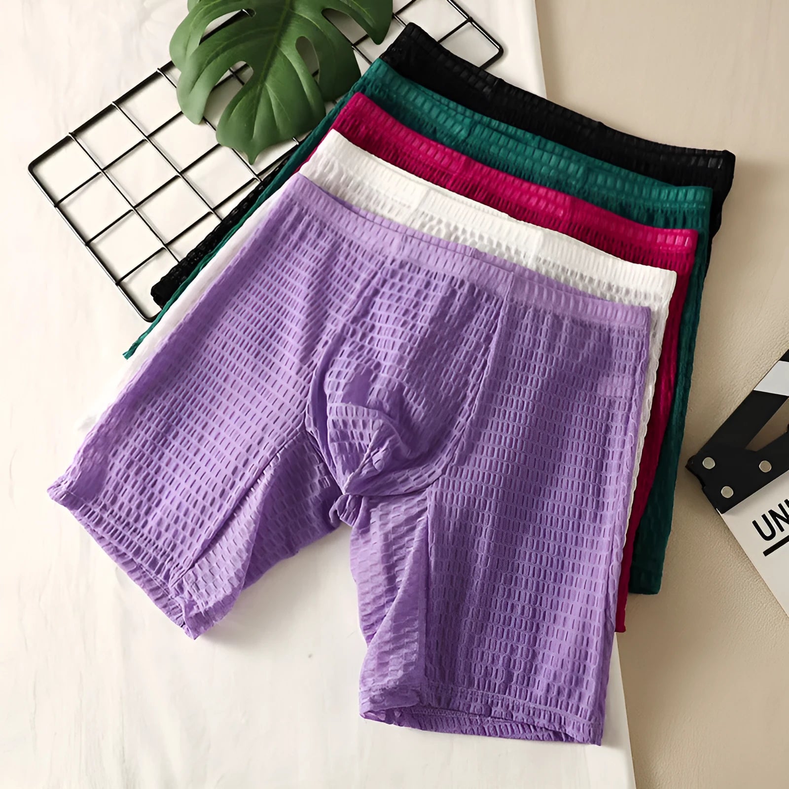 Men's solid colour lace boxer shorts on a white background, showing shaping design.