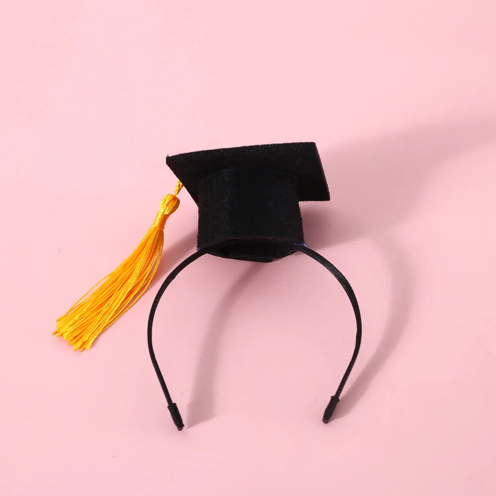 Small pet wearing a felt Doctor's Degree hair band and matching bow tie in British style.