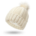 Women's black knit beanie hat with a white faux fur pom pom and satin lining for hair protection.