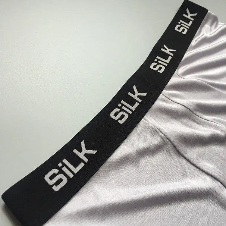 Men's loose navy blue silk shorts with a mid-waist design on a neutral background