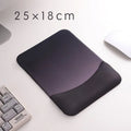 Square black silica gel wrist rest mouse pad with cloth surface on a desk.