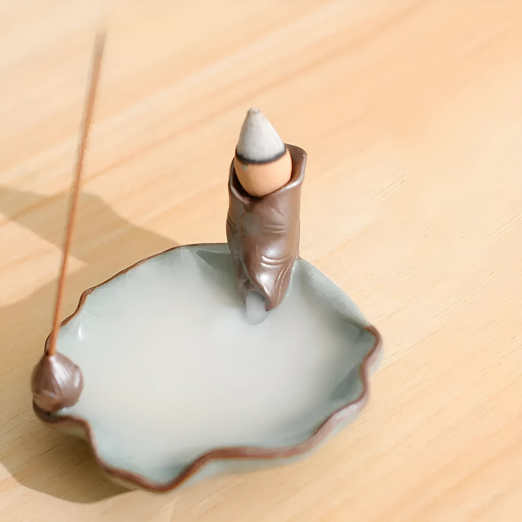 Square purple clay ceramic reverse flow incense burner with lotus and plum blossom decoration.
