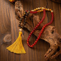 Vintage bohemian style long bead necklace with tassel and matching bracelet on grey background