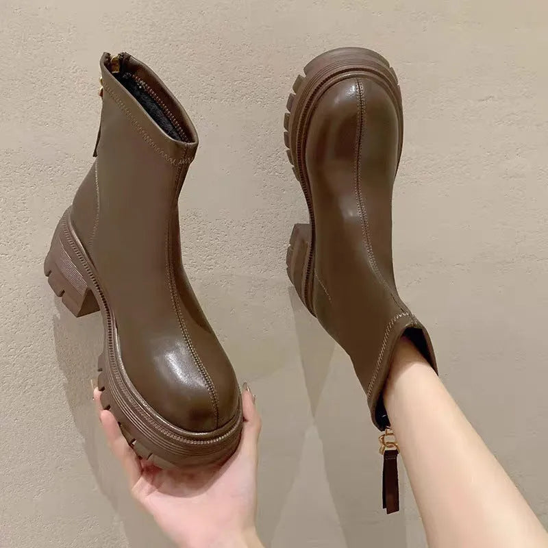 White platform ankle boots for women with thick foam rubber sole, mid-calf shaft, square heel, round toe, and back zipper.