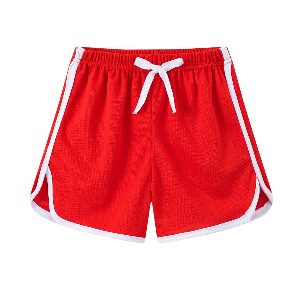 Children's polyester holiday shorts in multiple colours and patterns including stripes, leopard print, and pineapple design.