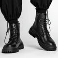 Men's black and brown mid-top leather boots with flat rubber soles.